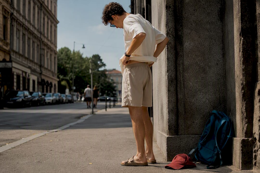 Young adult adjusting summer streetwear outfit outdoors