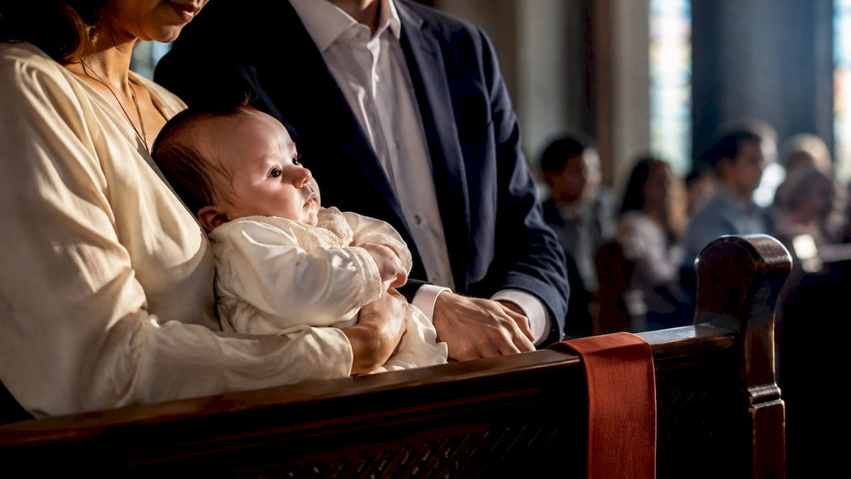 Adults holding baby during baptism ceremony